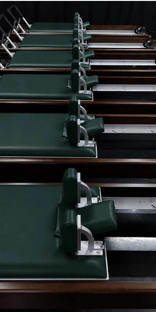 Referencia del estudio: una fila de reformers con tapizado verde profundo
